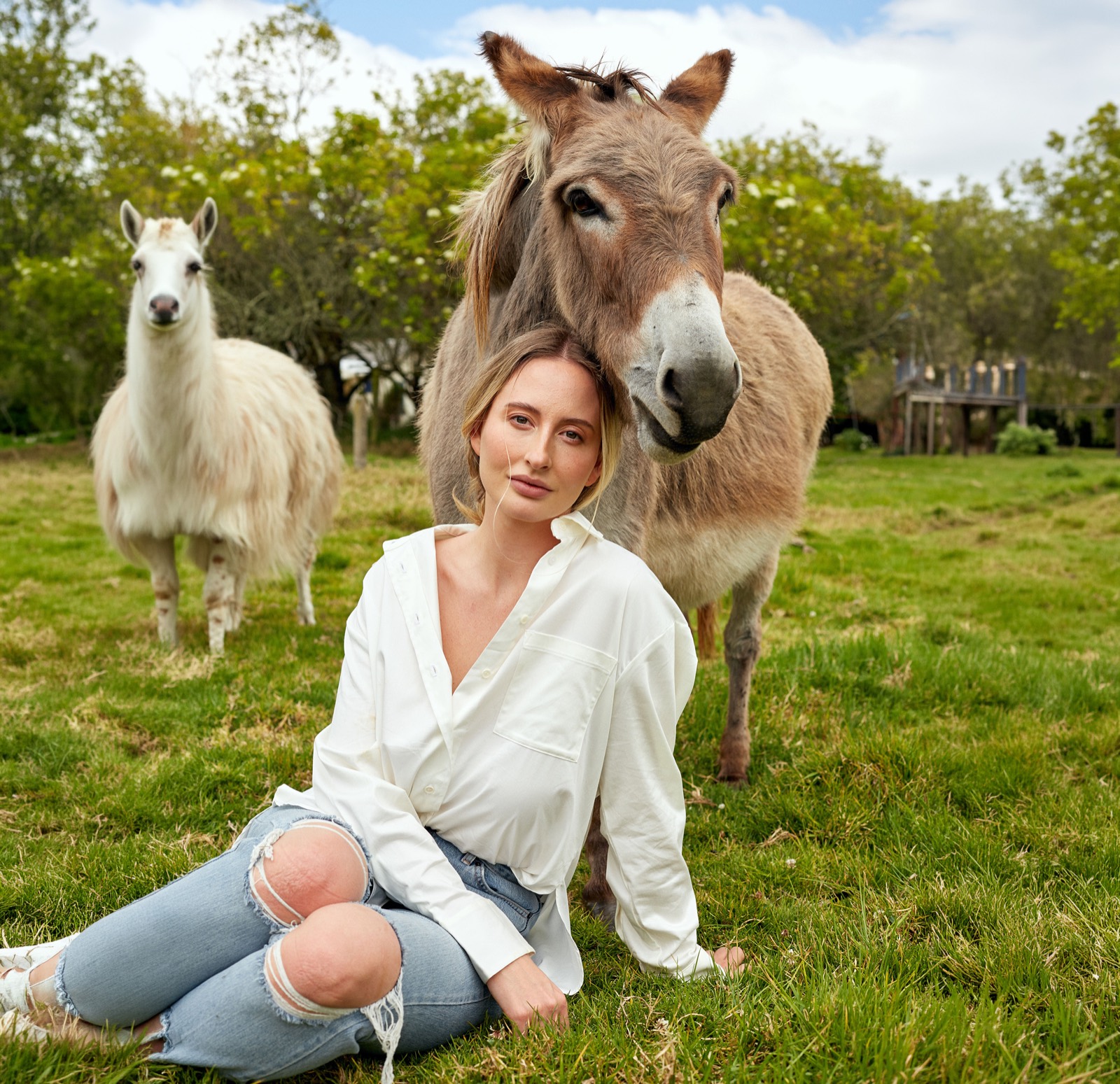 Sophia in a field resting against a rescued donkey